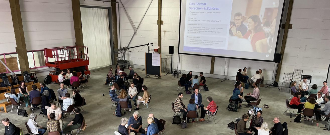 Ein großer Veranstaltungssaal mit vielen Gesprächsgruppen