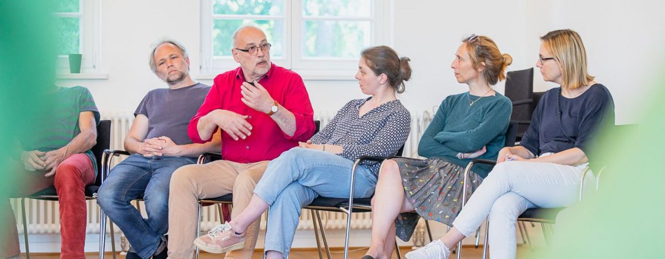 Gesprächskreis aus 5 Personen die nebeneinander sitzen