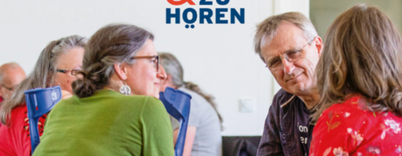 Vier Personen im Stuhlkreis diskutieren. 
