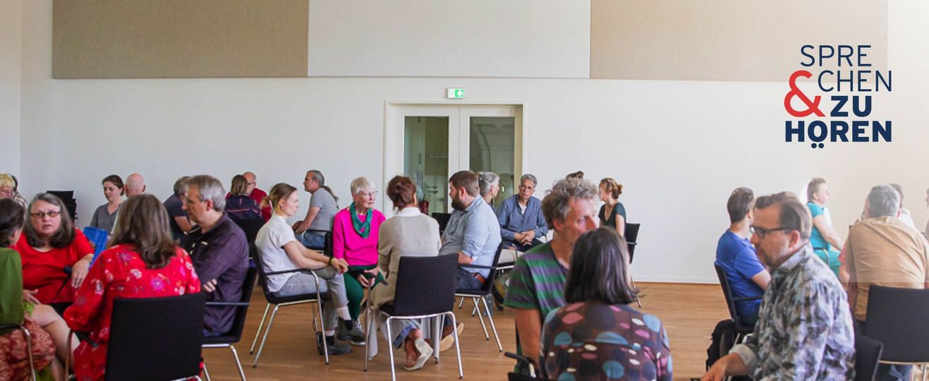 Menschen in Stuhlkreisen (3-4 Personen) in einem hellen Saal, oben rechts das Logo „Sprechen & Zuhören".