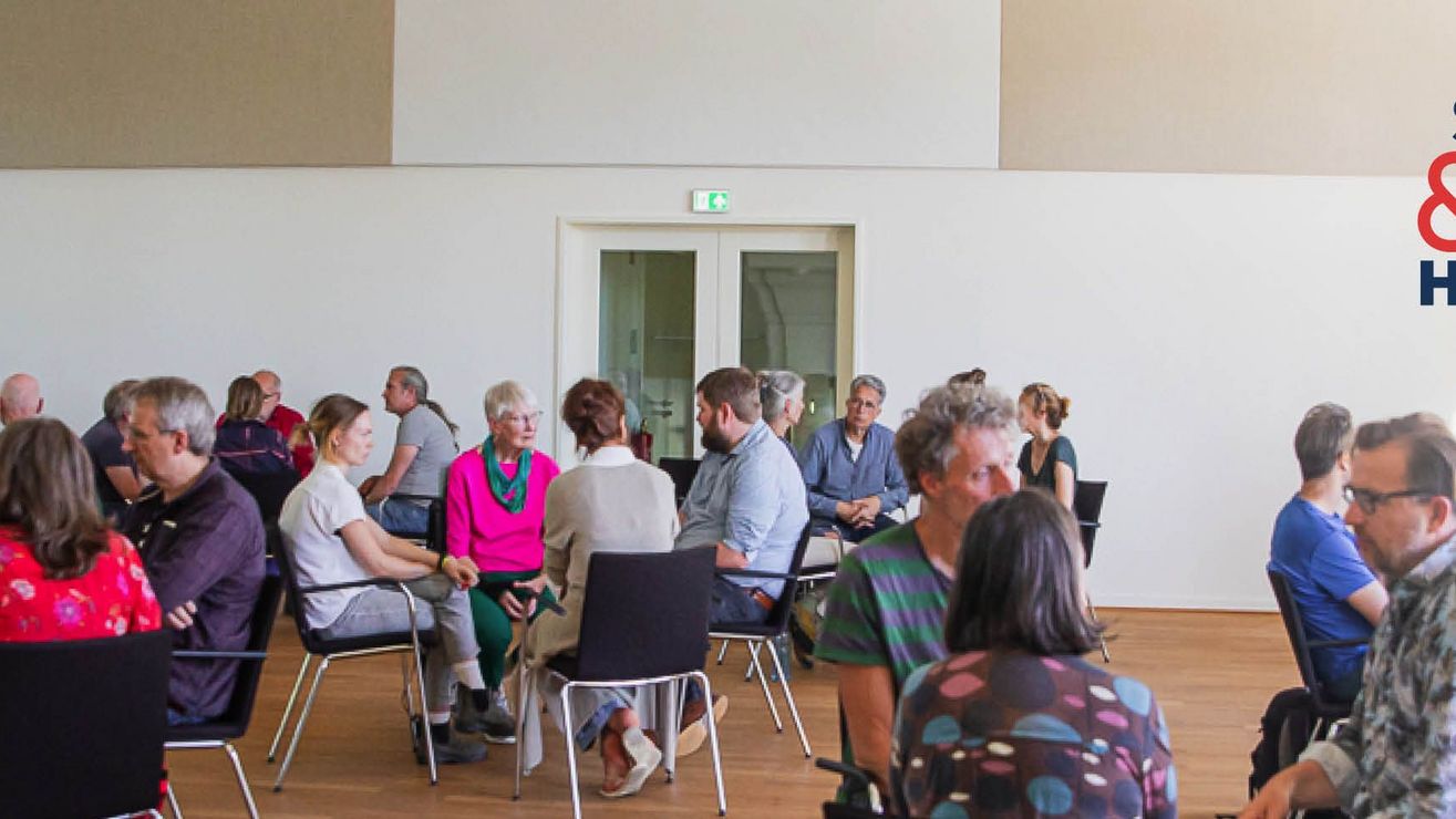 Menschen in Stuhlkreisen (3-4 Personen) in einem hellen Saal, oben rechts das Logo „Sprechen & Zuhören".