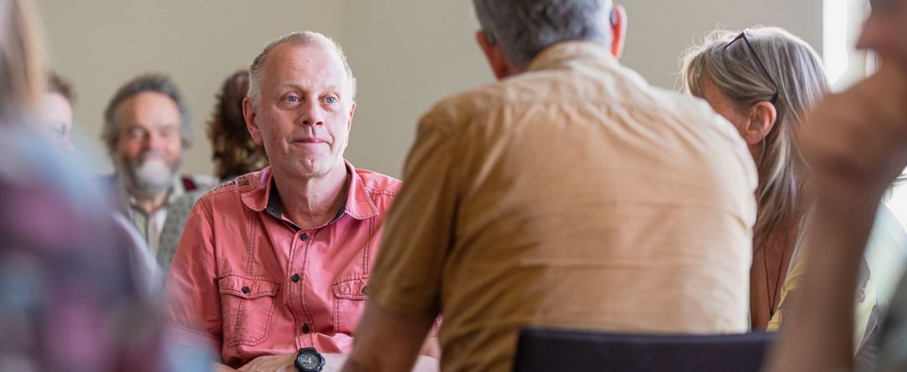 Vier Menschen im Stuhlkreis diskutieren. 